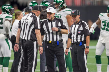 referee's in a huddle discussing calls; business law