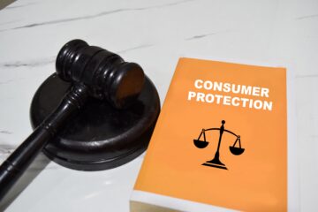 Concept of Consumer protection write on book and gavel isolated on Wooden Table. Orange County Business Law